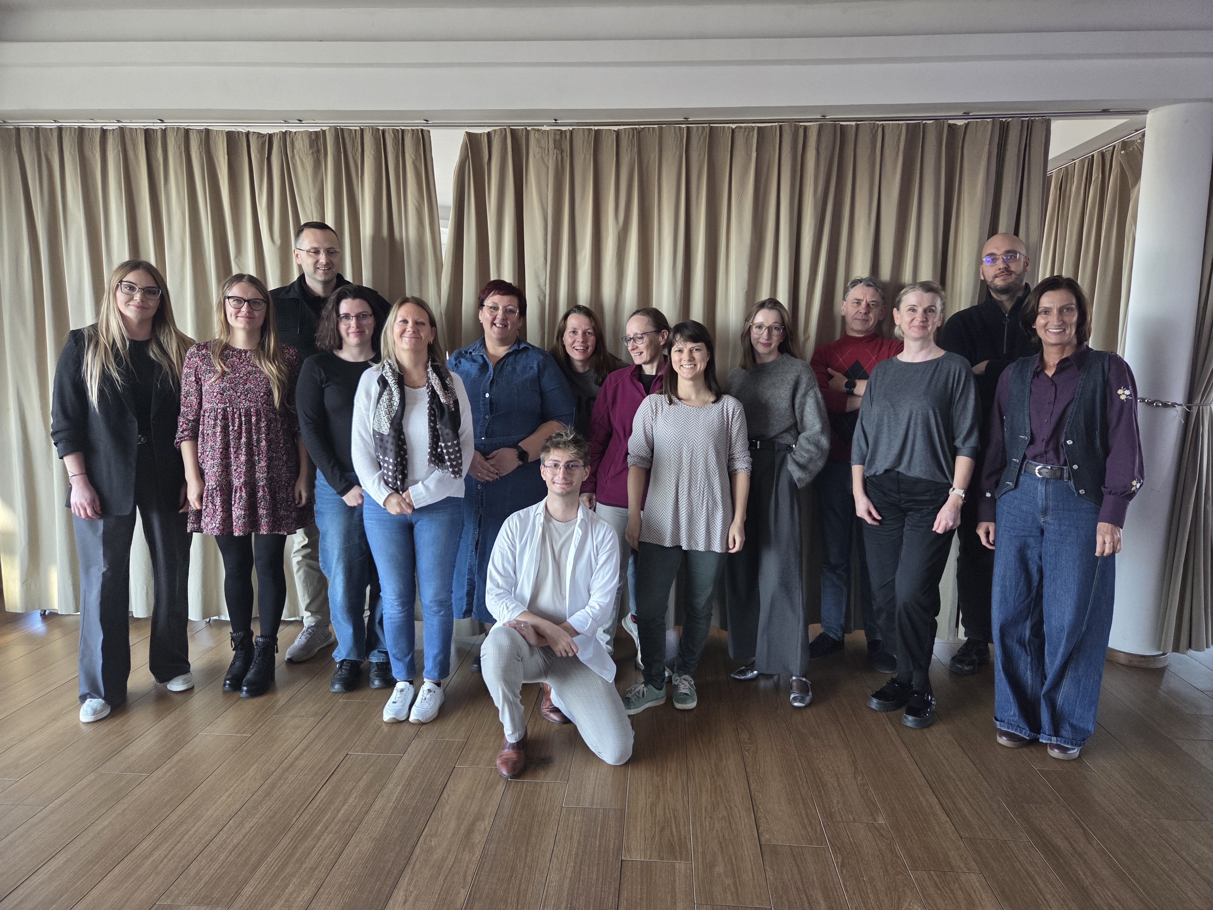 Grupa ludzi na tle kotary