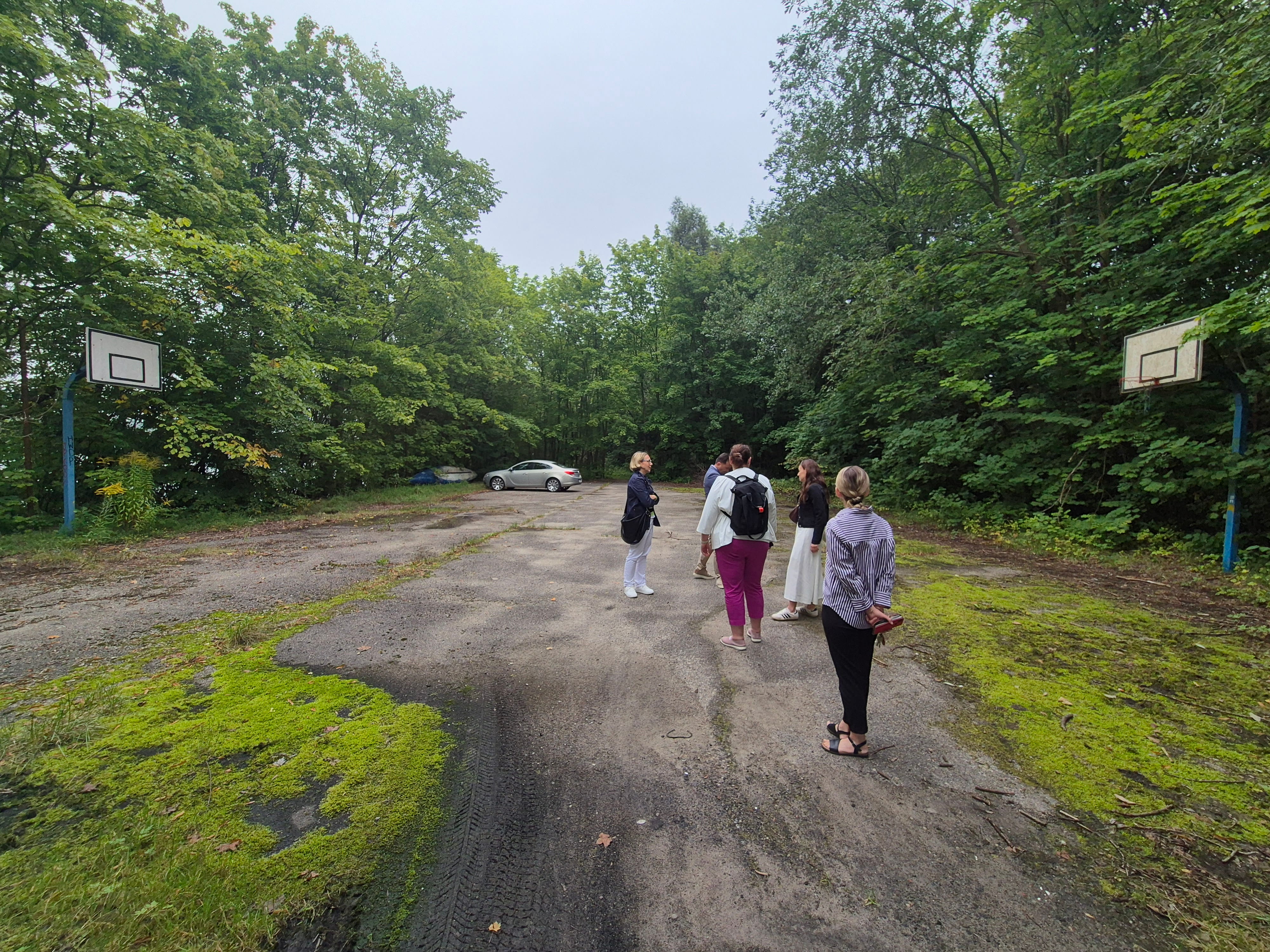 Grupa ludzi na zaniedbanym boisku