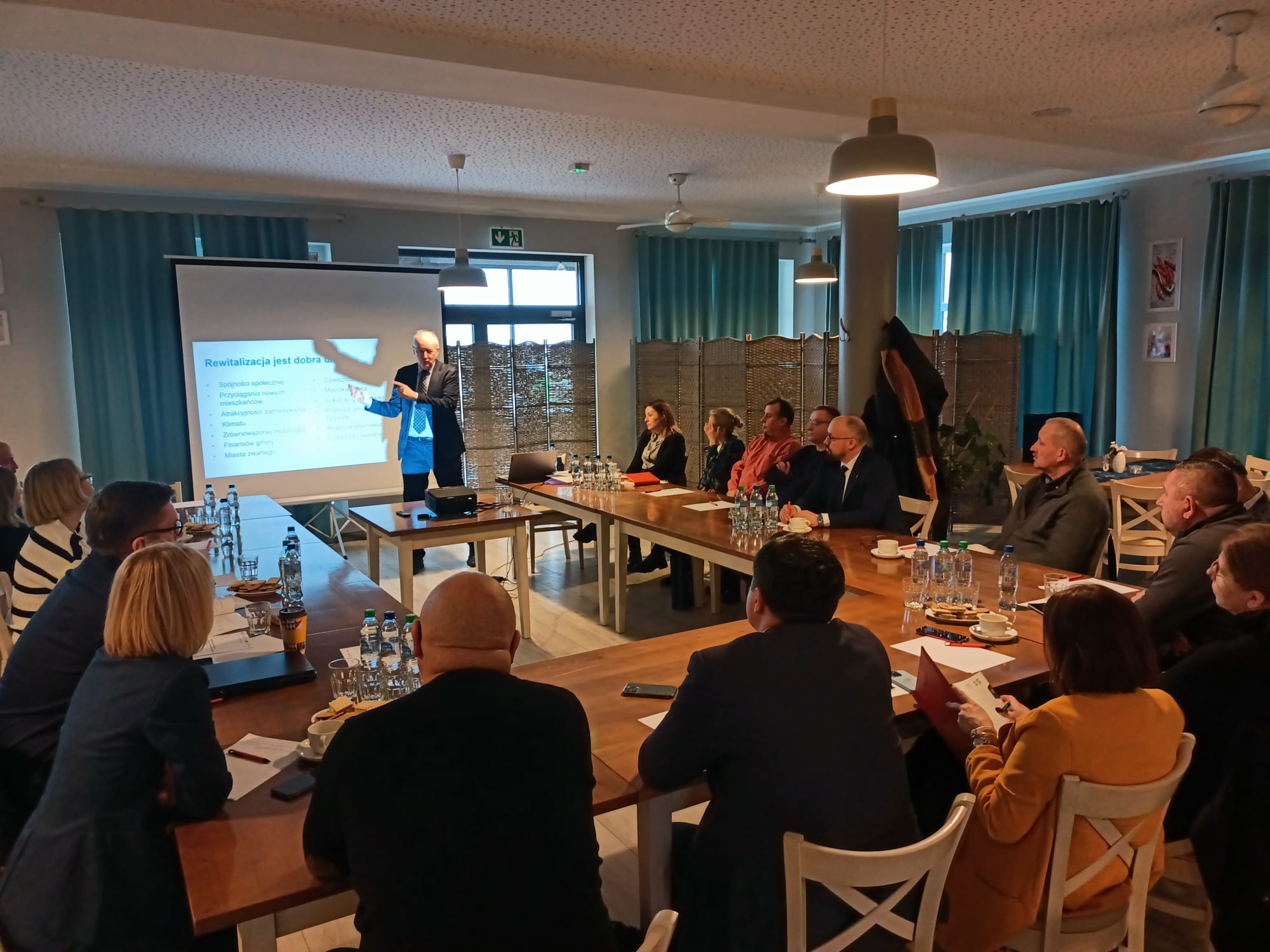 Grupa ludzi słuchająca prezentacji