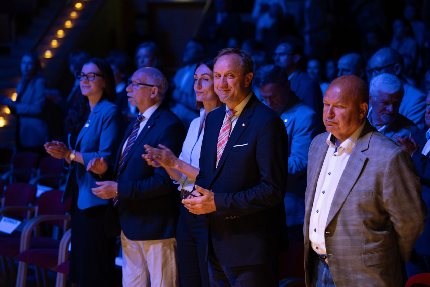 Cztery osoby. W tle inni goście konferencji