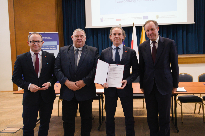 Marszałek Mieczysław Struk, wicemarszałek Marcin Skwierawski i dwie inne osoby prezentują podpisaną umowę