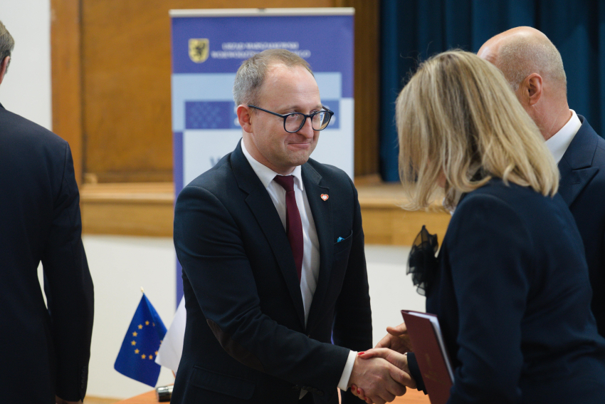 Wicemarszałek Marcin Skwierawski uściska dłoń jakiejś kobiecie
