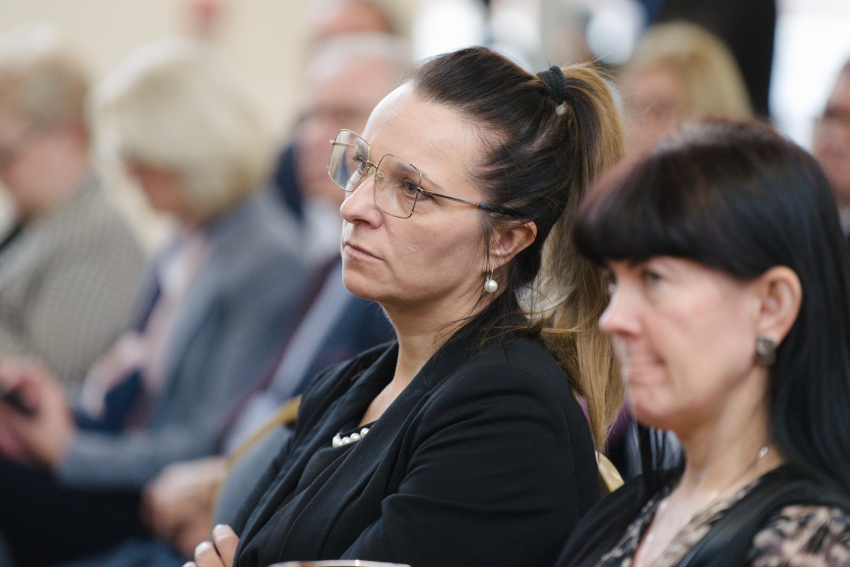 Osoby siedzą na sali podczas wydarzenia