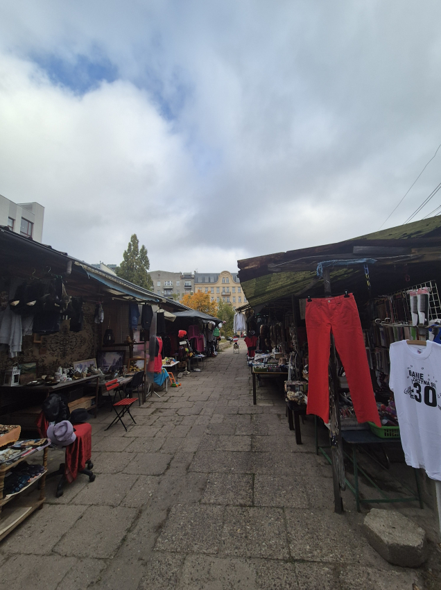 Stare bazary z ubraniami po dwóch stronach betonowego chodnika