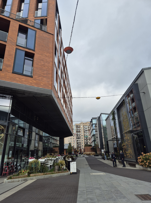 Wyremontowana uliczka z nawierzchnią z płyt betonowych. Po bokach nowoczesne budynki