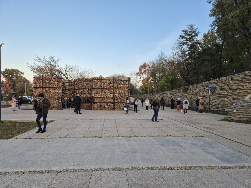 Ludzie spacerujący po placu otoczonym instalacjami z kamieni o nieregularnym kształcie