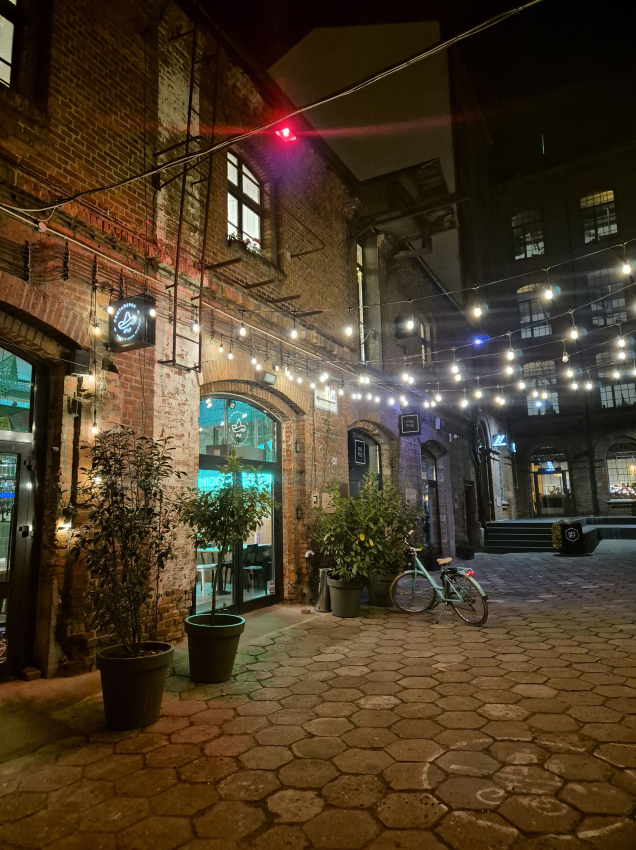 Restauracja w budynku z czerwonej cegły z powieszonymi lampkami ogrodowymi na zewnątrz