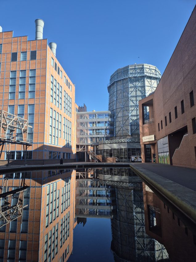 Zbiornik wodny na tle wyremontowanych budynków po dawnych fabrykach