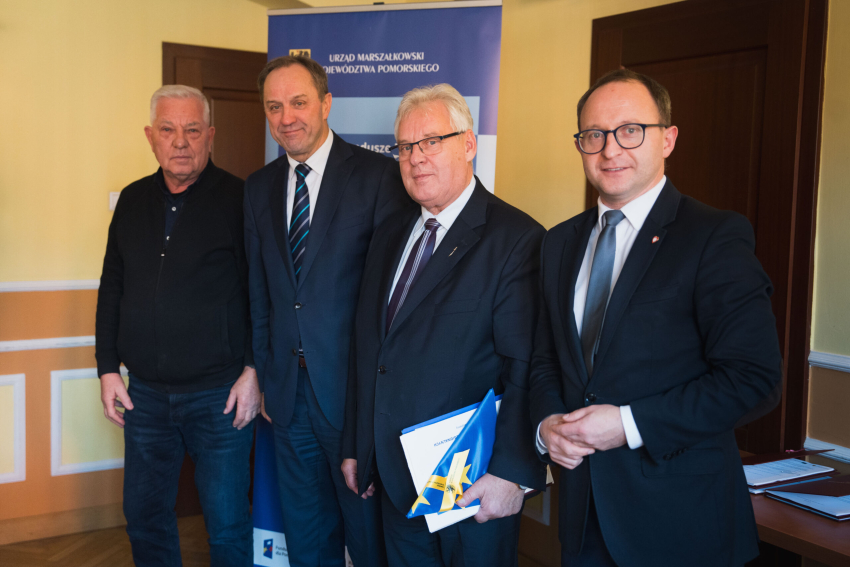 Cztery osoby prezentują podpisaną umowę, w tym marszałek Mieczysław Struk oraz wicemarszałek Marcin Skwierawski