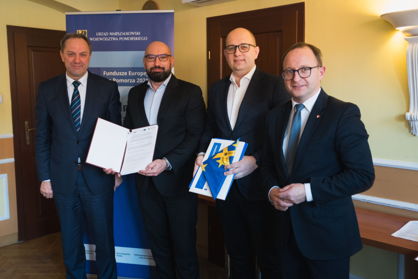 Cztery osoby prezentują podpisaną umowę, w tym marszałek Mieczysław Struk oraz wicemarszałek Marcin Skwierawski