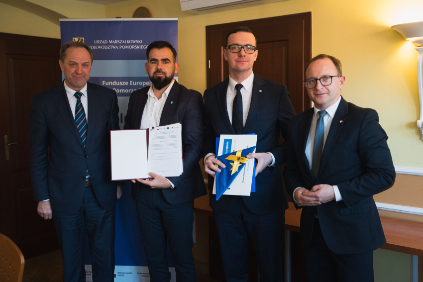 Cztery osoby prezentują podpisaną umowę, w tym marszałek Mieczysław Struk oraz wicemarszałek Marcin Skwierawski