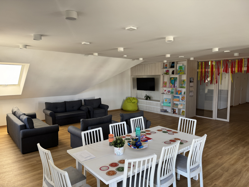 Przestrzeń wspólna budynku. Krzesła, sofy, telewizor, regały na książki