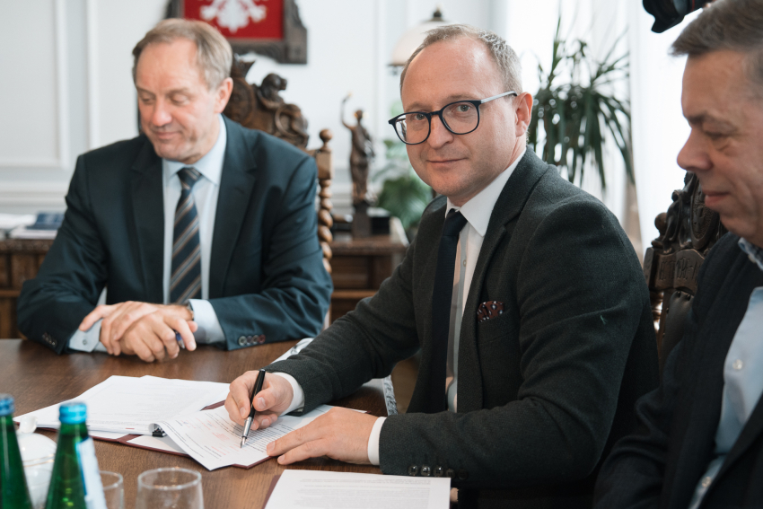 Wicemarszałek Marcin Skwierawski podpisuje dokument, w tle marszałek Mieczysław Struk