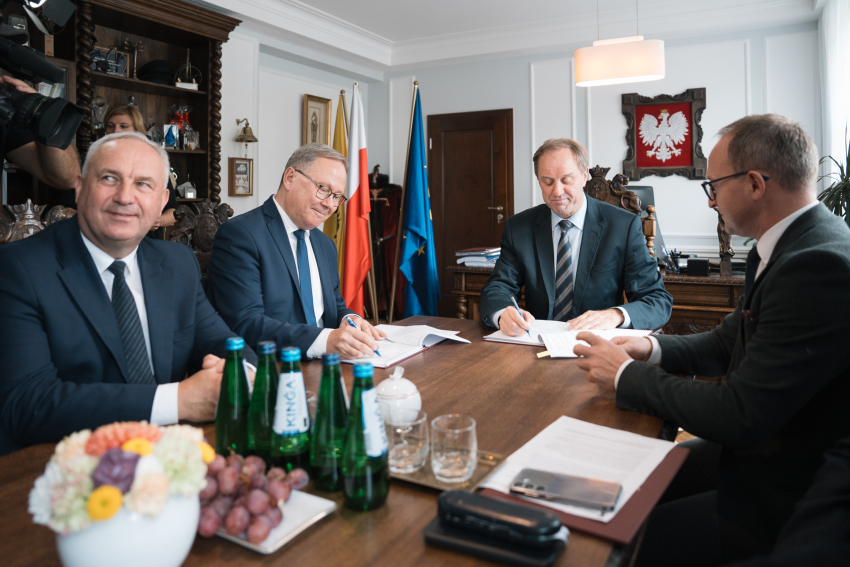 Czterech uczestników wydarzenia siedzi przy stole, wśród nich: marszałek Mieczysław Struk, wicemarszałek Marcin Skwierawski oraz prezydent Starogardu Gdańskiego Janusz Stankowiak