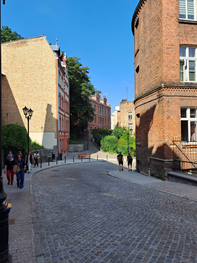 Brukowana uliczka między zabytkowymi kamienicami