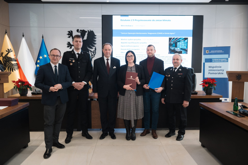 sześć osób prezentuje podpisaną umowę