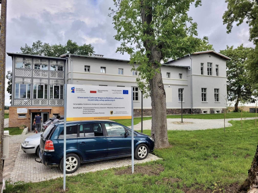 budynek Centrum, tablica informacyjna, auto w tle