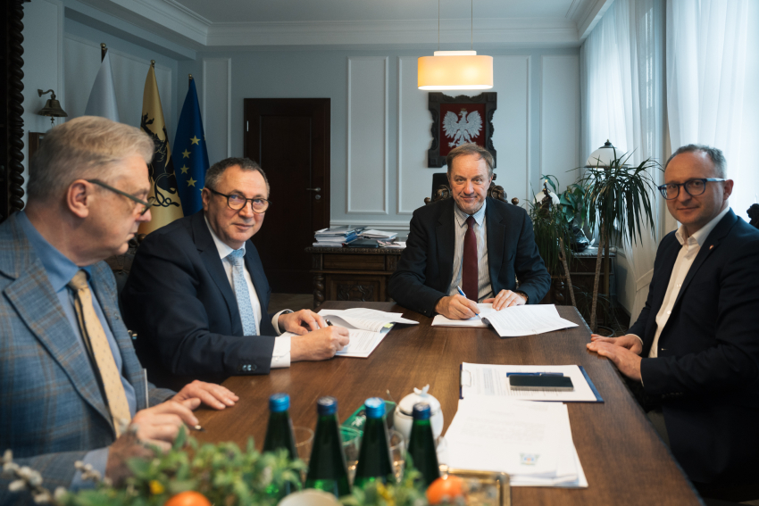Dwóch wiceprezesów Copernicus Podmiot Leczniczy Sp. z o.o. siedzi przy stole i podpisuje uroczyście umowę o dofinansowanie z marszałkiem woj. pomorskiego Mieczysławem Strukiem oraz wicemarszałkiem Marcinem Skwierawskim