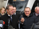 Grupa ludzi. Na pierwszym planie mikrofon w tle pociag