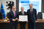 Marszałek Mieczysław Struk, wicemarszałek Marcin Skwierawski oraz przedstawiciel władz regionu pozują do uroczystego zdjęcia z podpisaną umową