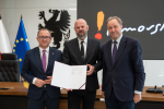 Marszałek Mieczysław Struk, wicemarszałek Marcin Skwierawski oraz przedstawiciel władz regionu pozują do uroczystego zdjęcia z podpisaną umową