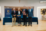 marszałkowie oraz dwóch przedstawicieli lokalnych władz pozują do zdjęcia z umową i flagą UE