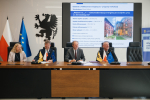 marszałek Mieczysław Struk, wicemarszałek Leszek Bonna oraz dwie inne osoby podpisują umowę o dofinansowanie przy stole prezydialnym