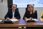 Wicemarszałek Marcin Skwierawski oraz przedstawicielka jednego z powiatowych szpitali siedzą przy stole prezydialnym i podpisują umowę o dofinansowanie