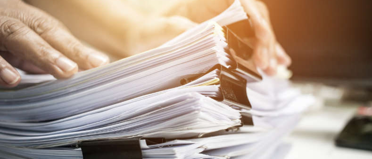 stos dokumentów, a na nich dłonie