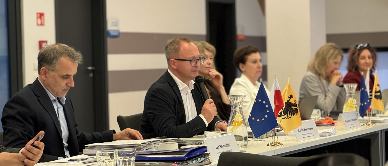 Przy stole prezydialnym siedzą, od lewej: Jan Szymański - dyrektor Departamentu Programów Regionalnych, prowadzący posiedzenie Marcin Skwierawski - wicemarszałek województwa pomorskiego, Magdalena Horodyska (Dyrekcja Generalna ds. Polityki Regionalnej i Miejskiej), Patrycja Szczygieł - zastępca dyrektora departamentu rozwoju regionalnego i przestrzennego, Agnieszka Surudo - zastępca dyrektora departamentu programów regionalnych oraz jeszcze jedna osoba
