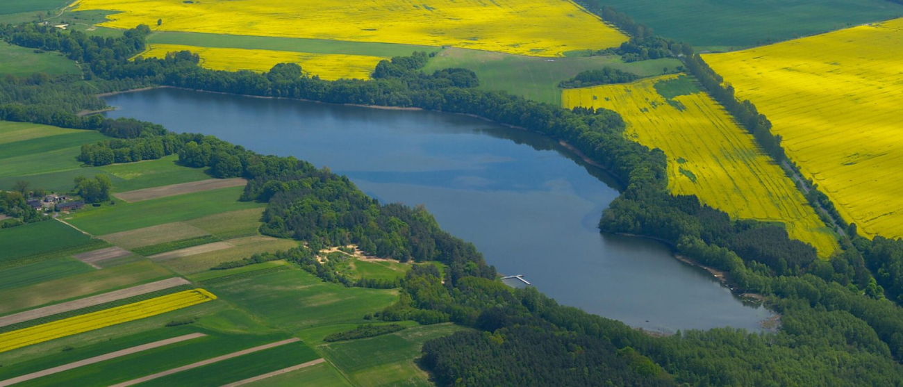 na zdjęciu jezioro, łąki i pola